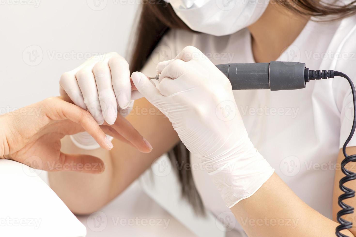 Manicure master removes nail polish photo