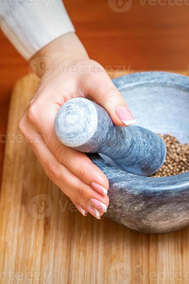 Hands grind dry pepper spices photo