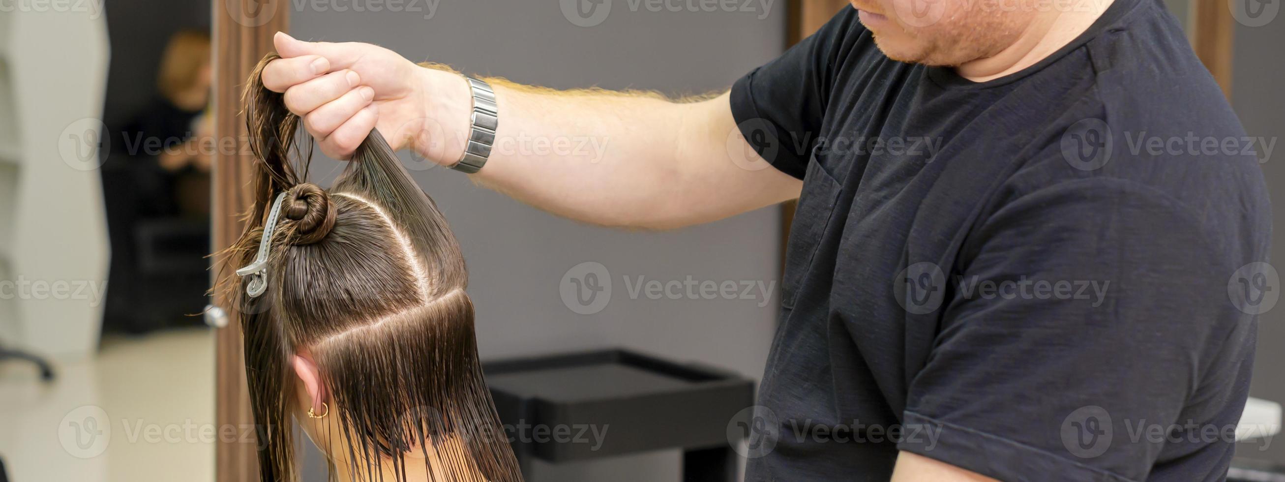 Male hairdresser splits long hair photo