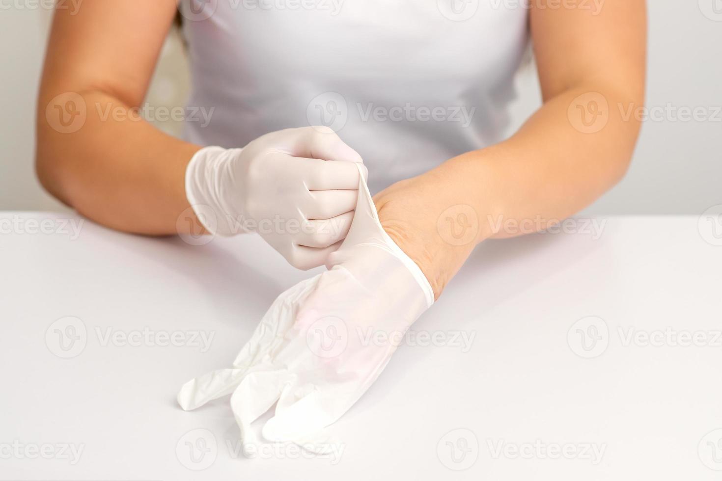 Doctor puts on white gloves photo