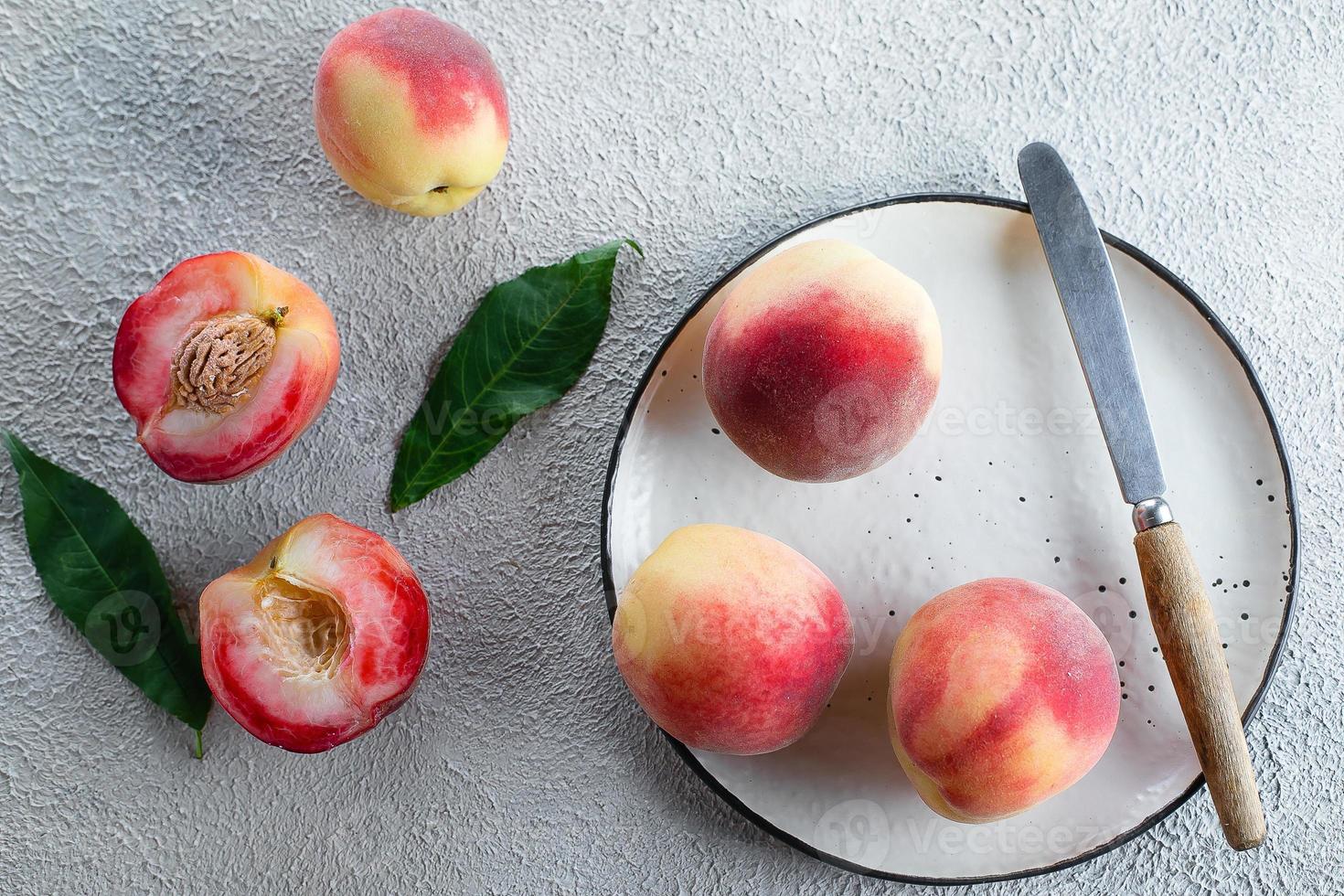 Fresh peaches. Peaches on light concrete background. Flat lay, top view. photo