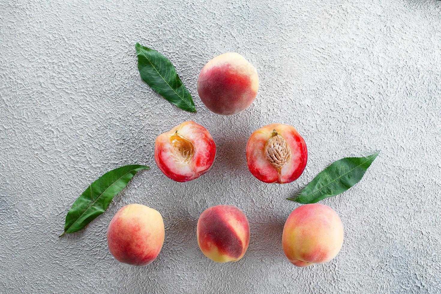 Fresh peaches. Peaches on light concrete background. Flat lay, top view. photo