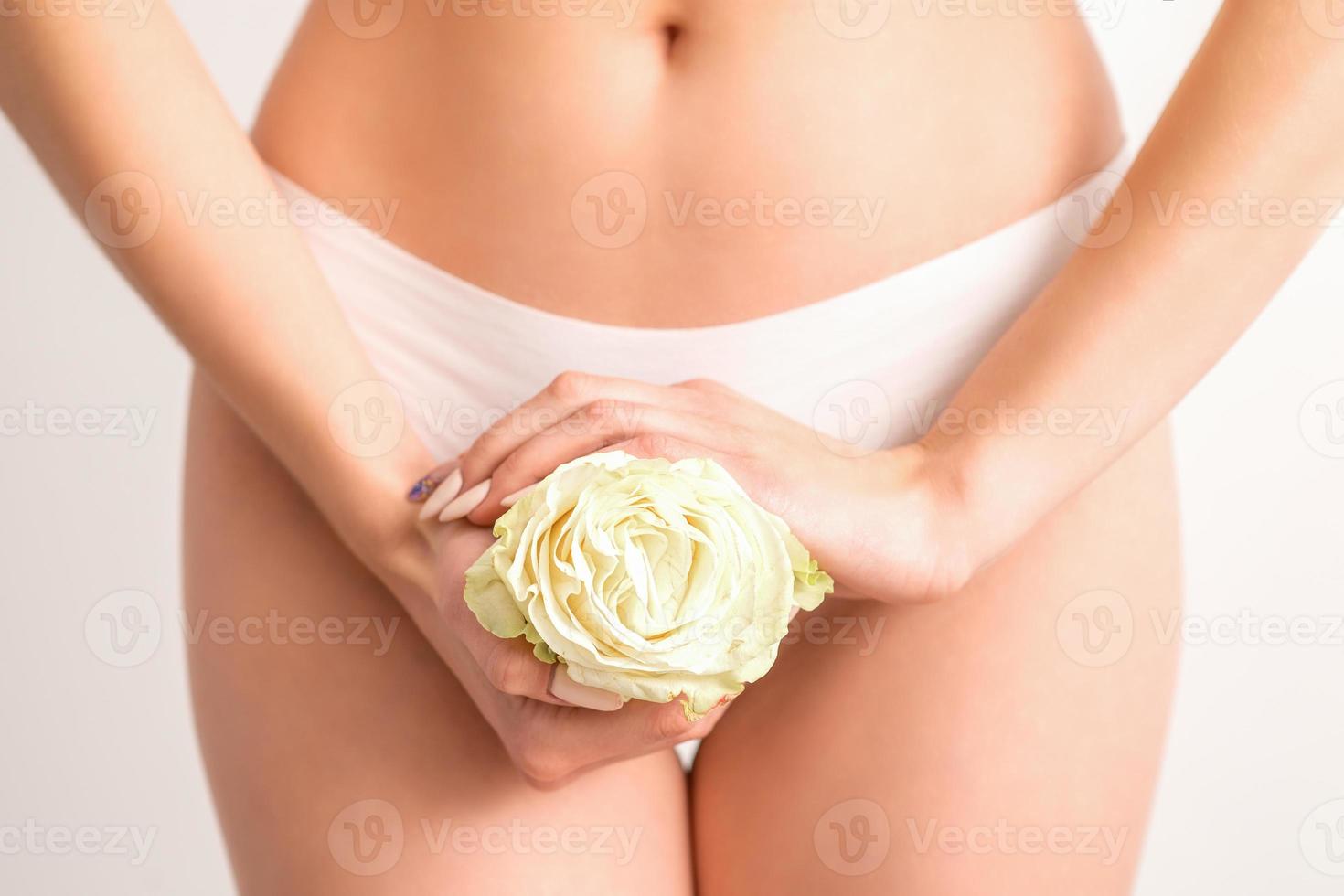 Hands holding flower covers bikini zone photo