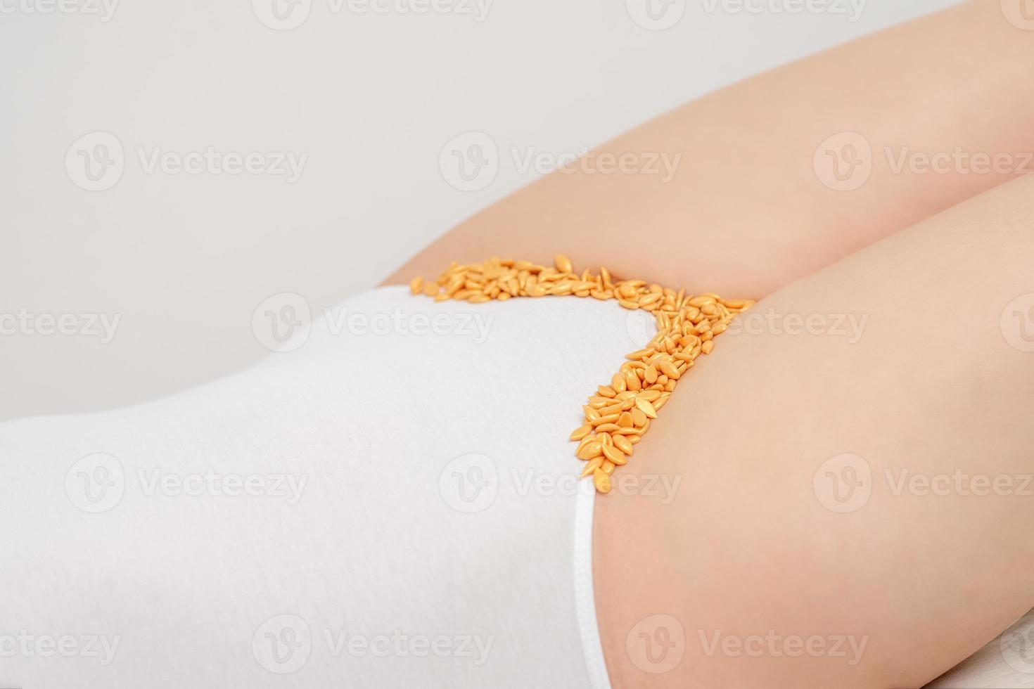 Wax beans lying down on bikini zone photo