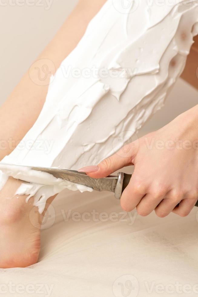 Woman shaving legs with knife photo