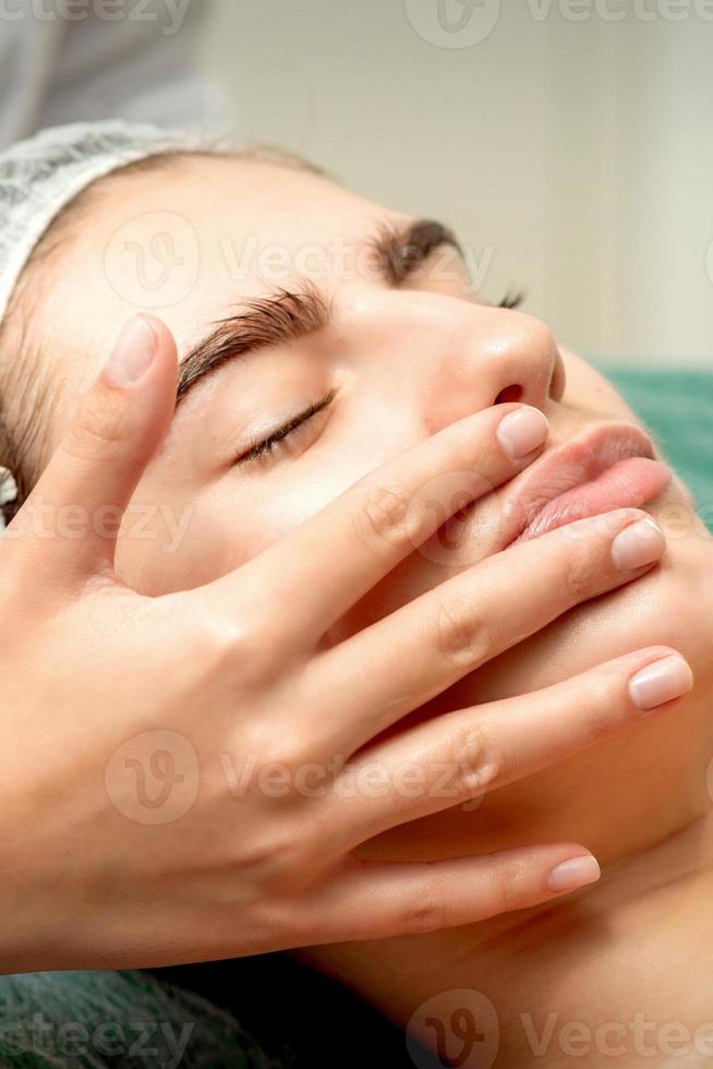 Young woman receiving facial massage photo