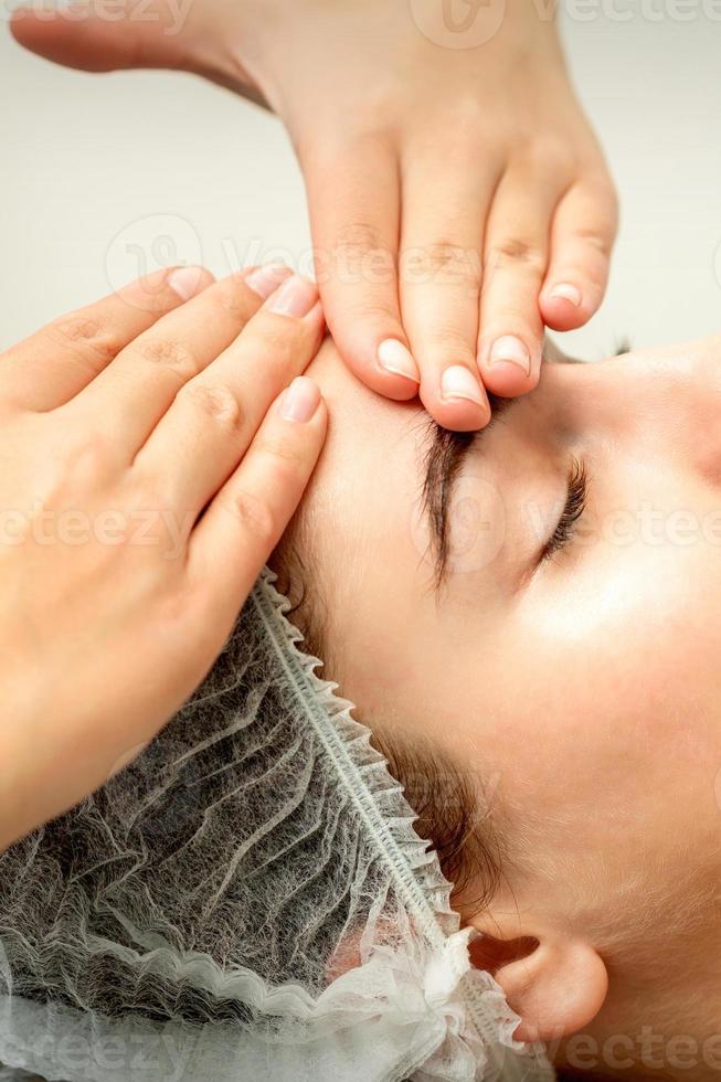 Young woman receiving facial massage photo