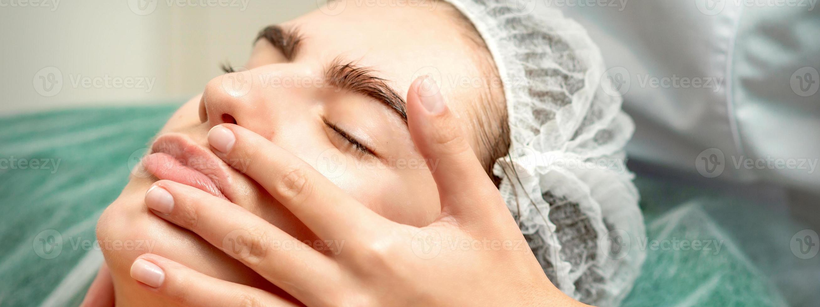 Young woman receiving facial massage photo