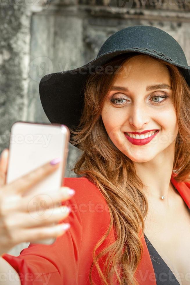 mujer tomando selfie en contra antiguo edificio foto