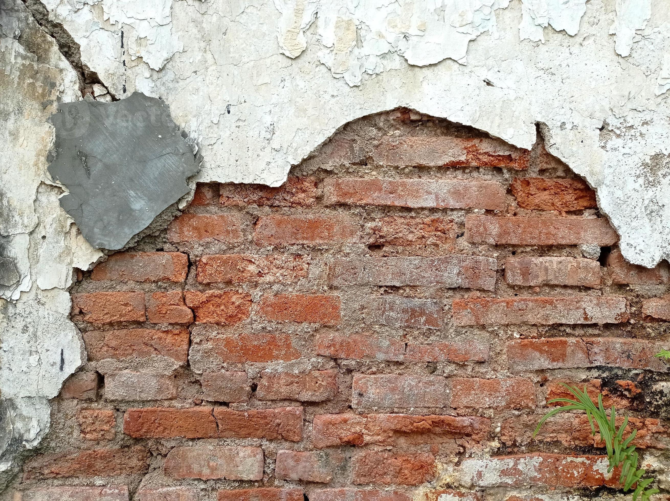 Broken wall revealing the bricks in it. Rustic and vintage wall