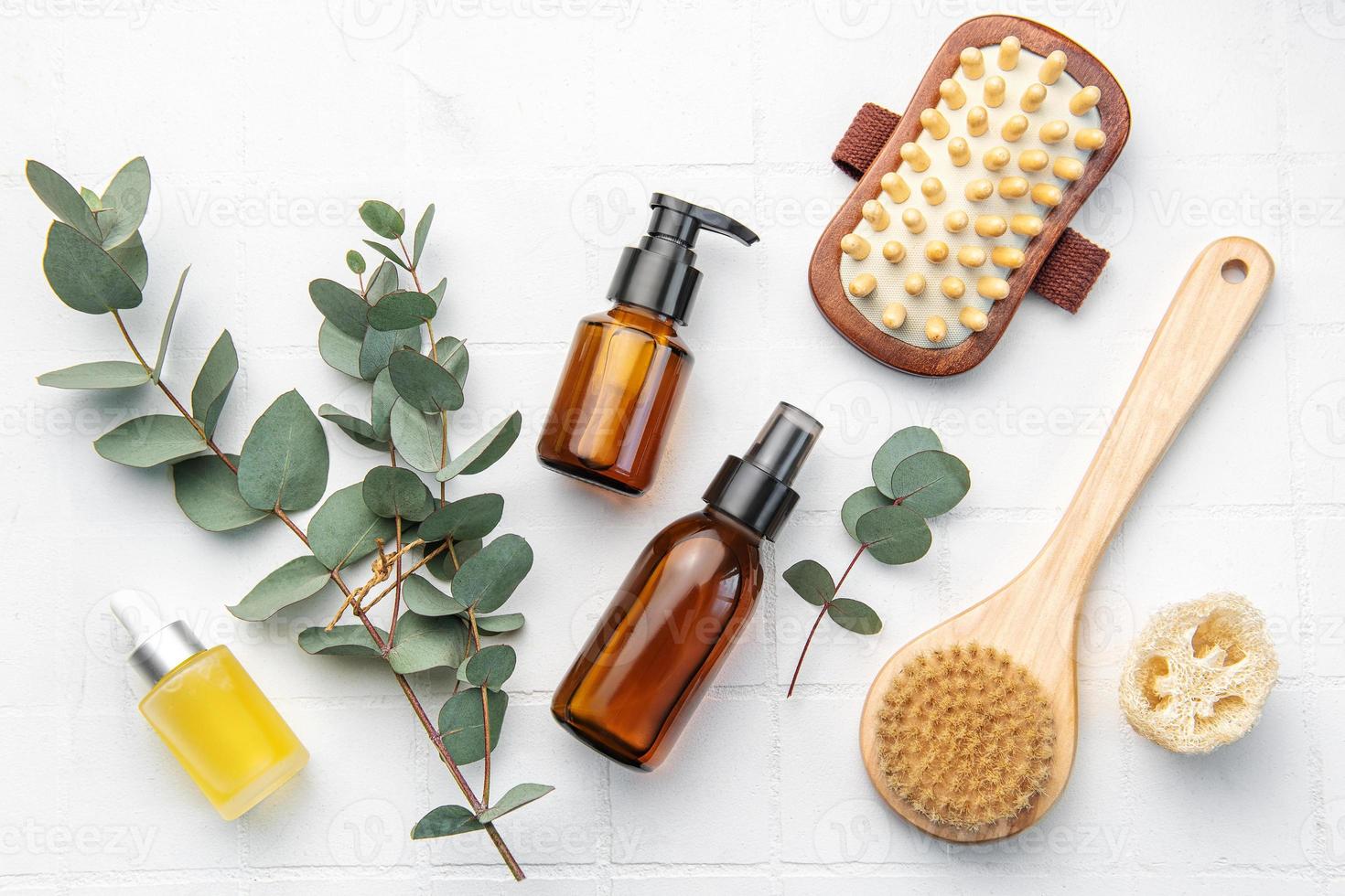 Spa treatment concept. natural spa cosmetics products with eucalyptus oil,, massage brush, eucalyptus leaf. photo