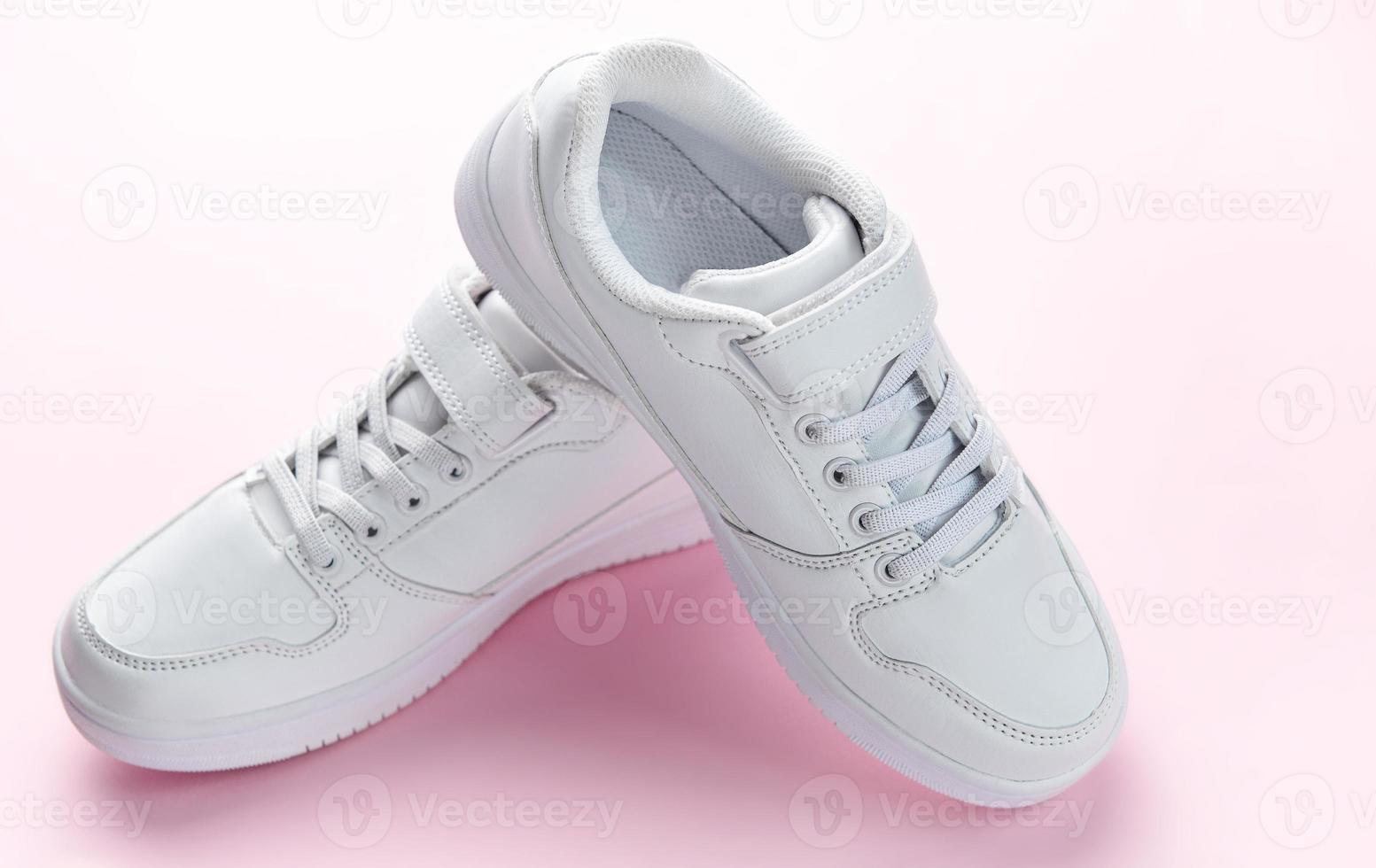 White sneakers on a pink background. photo