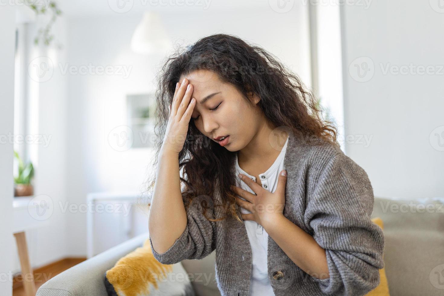 Breathing, respiratory problem, asthma attack, pressure, chest pain, sun stroke, dizziness concept. portrait of woman received heatstroke in hot summer weather, touching her forehead photo