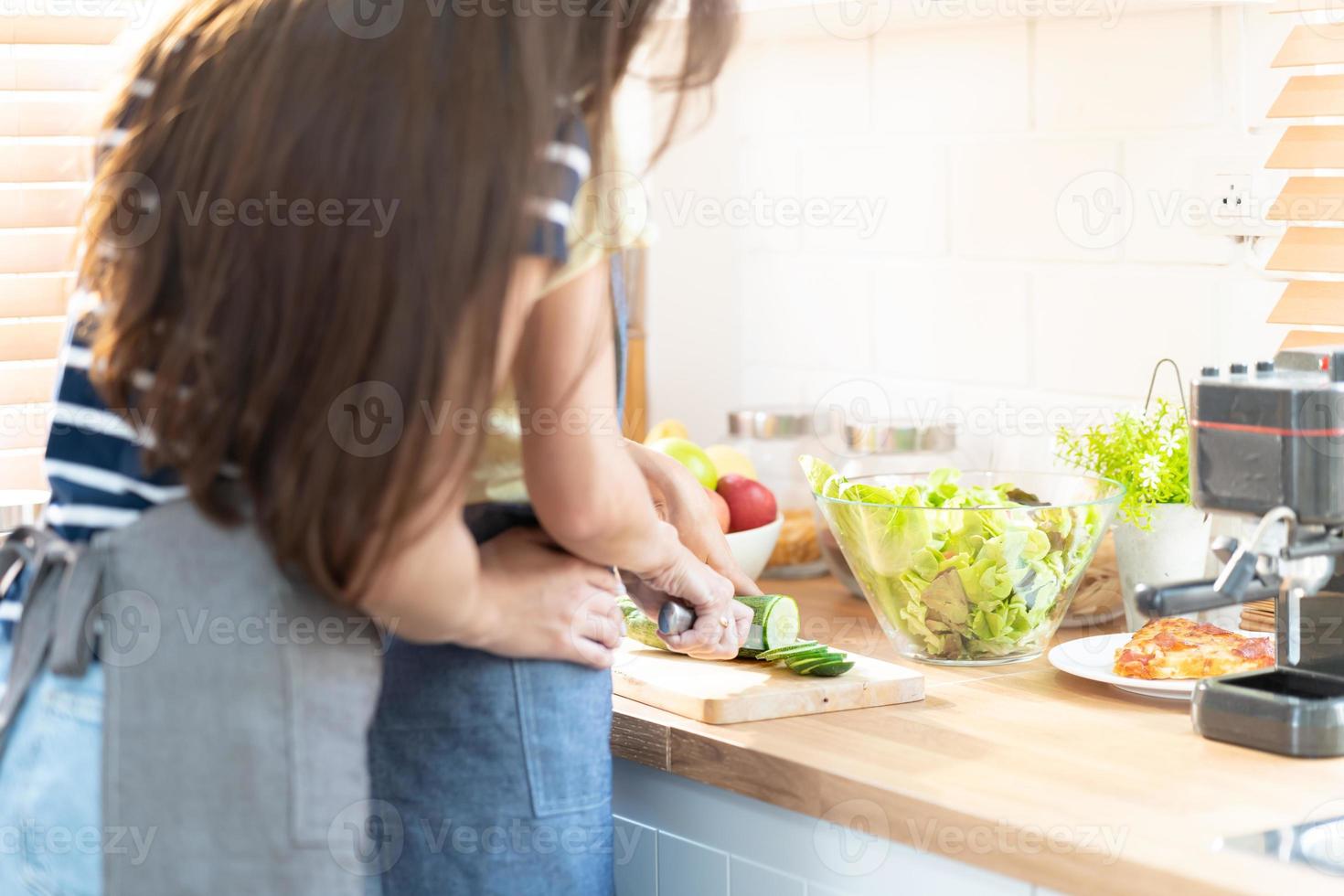 lesbiana Pareja en pie en cocina. lesbiana Pareja en pie en un moderno cocina detrás un mostrador Cocinando comida juntos. en amor lgbt libertad concepto. amoroso y cuidando Pareja cocinando. selectivo enfocar. foto