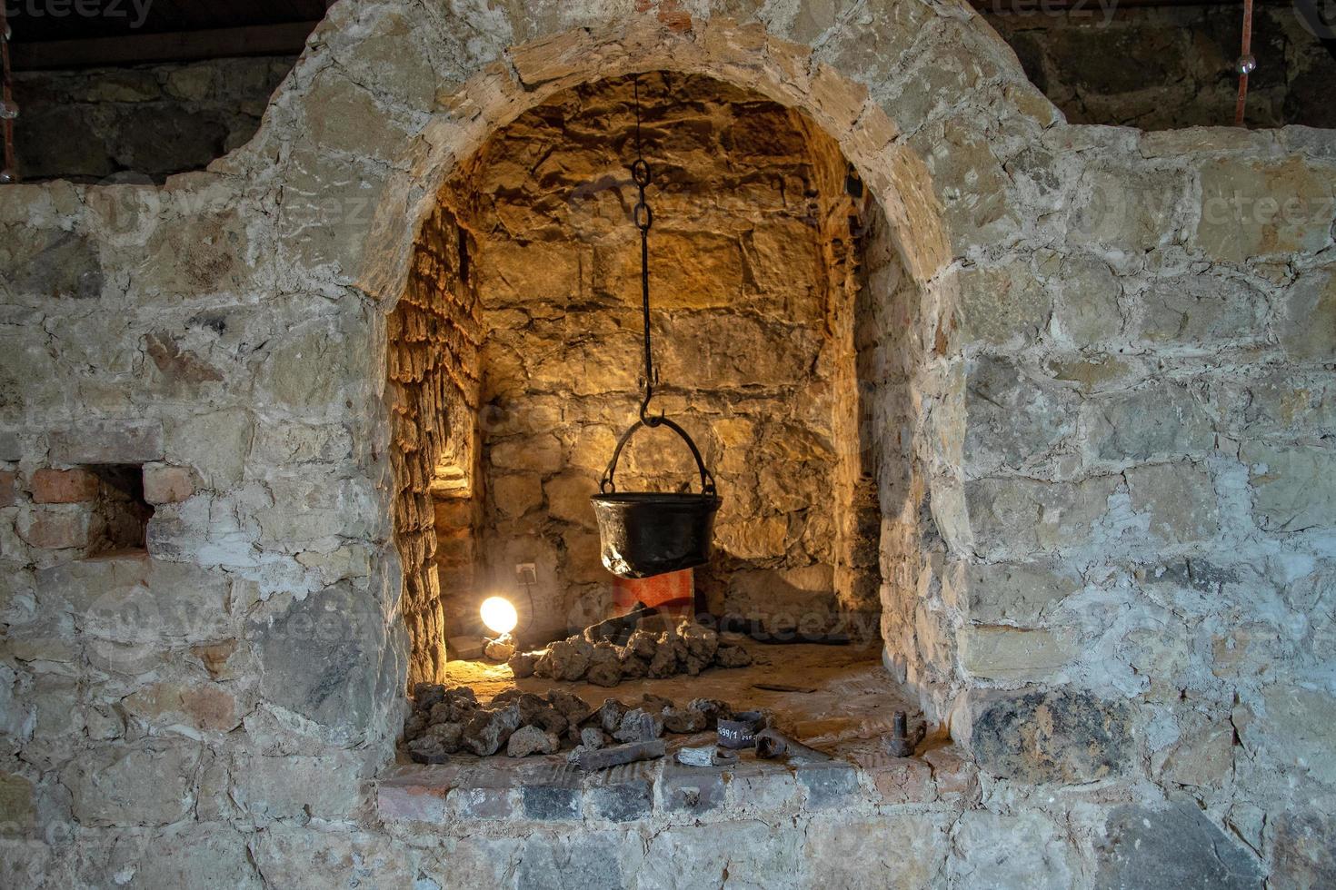 antique kitchen hearth in a historic castle with a metal pot photo