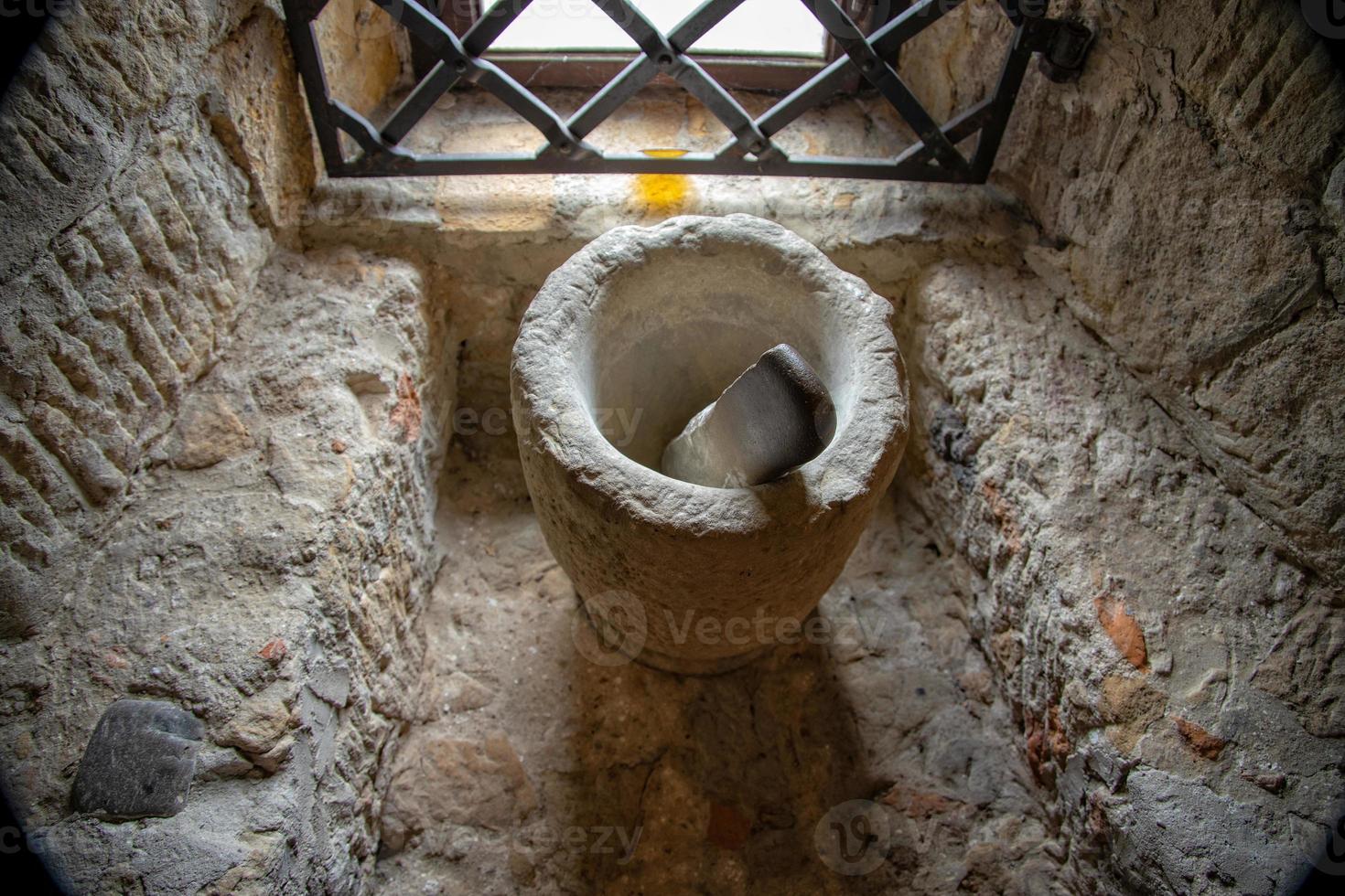 old antique stone kitchen mortar in the window of a medieval castle photo