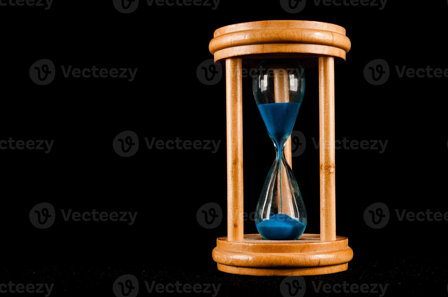 Hourglass on black background photo