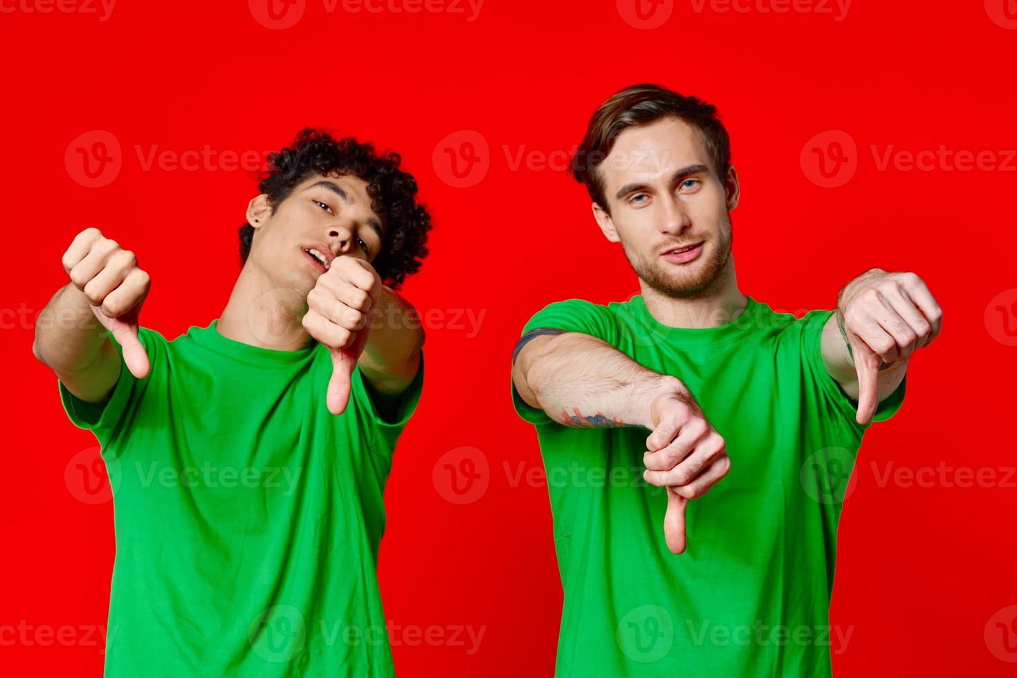 Cheerful friends in green t-shirts gesturing with hands isolated background photo