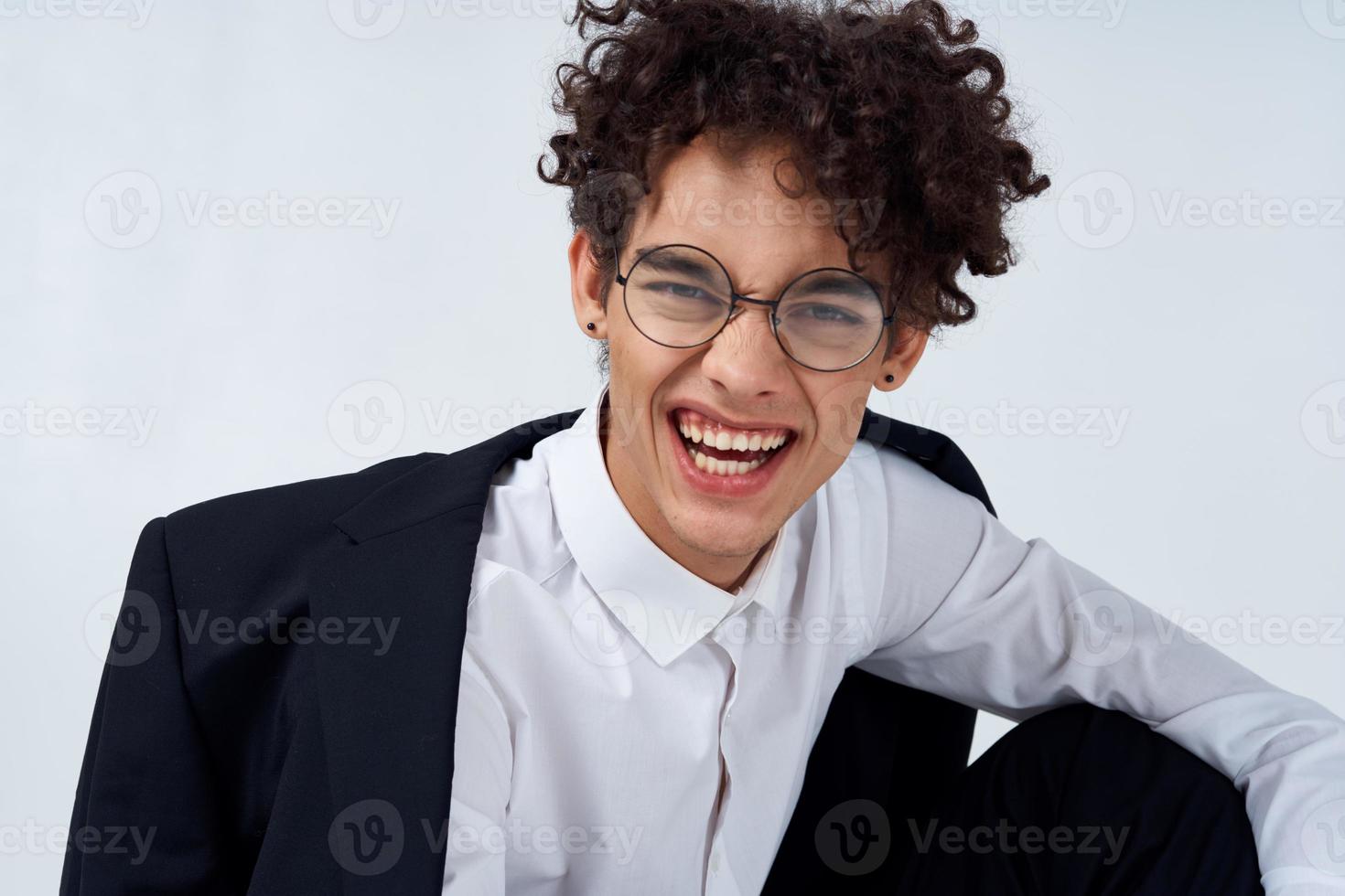 portrait of a curly-haired guy in a shirt in a jacket and glasses photo