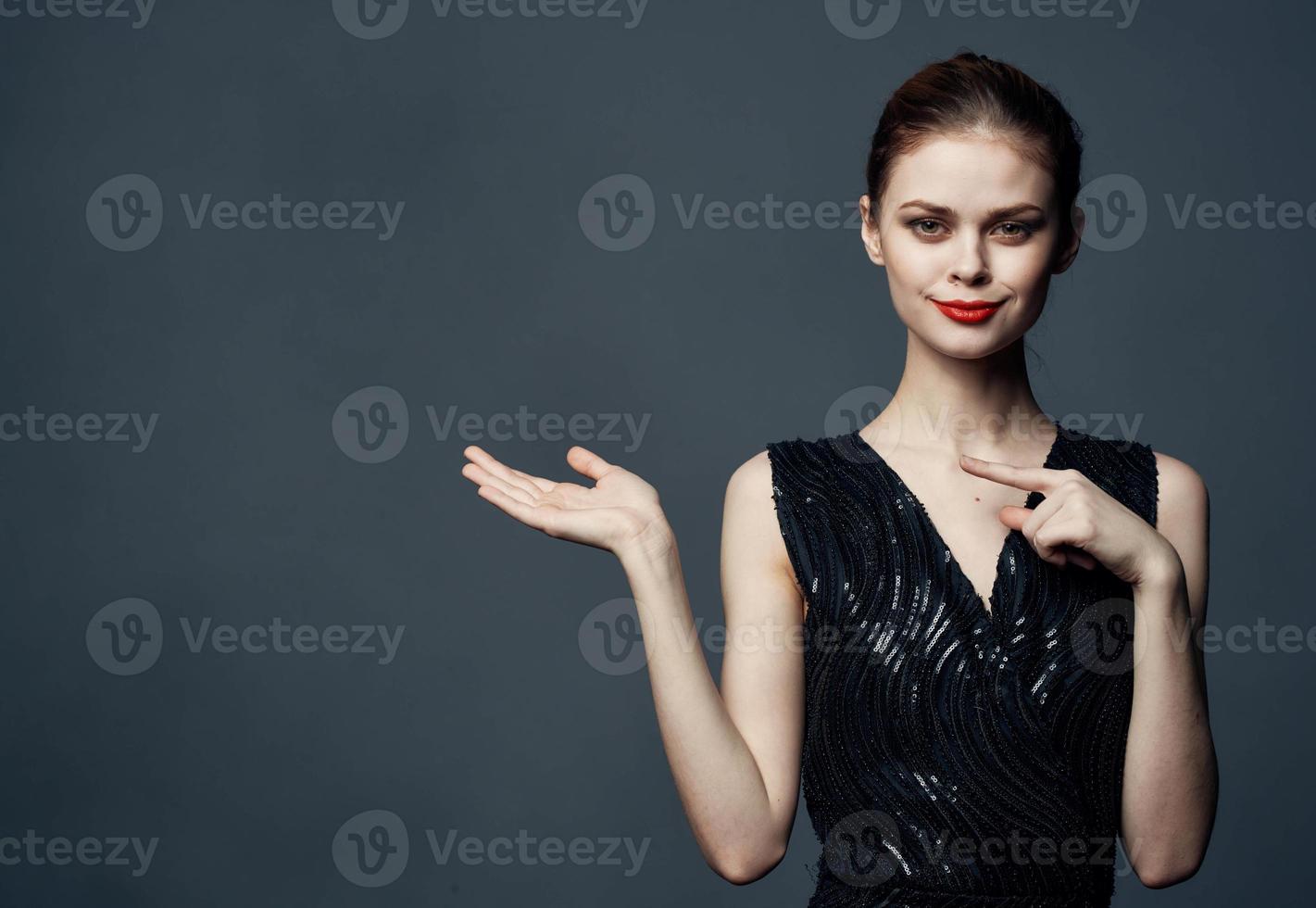 Woman shows emotions with hands to the sides on gray background Copy Space photo