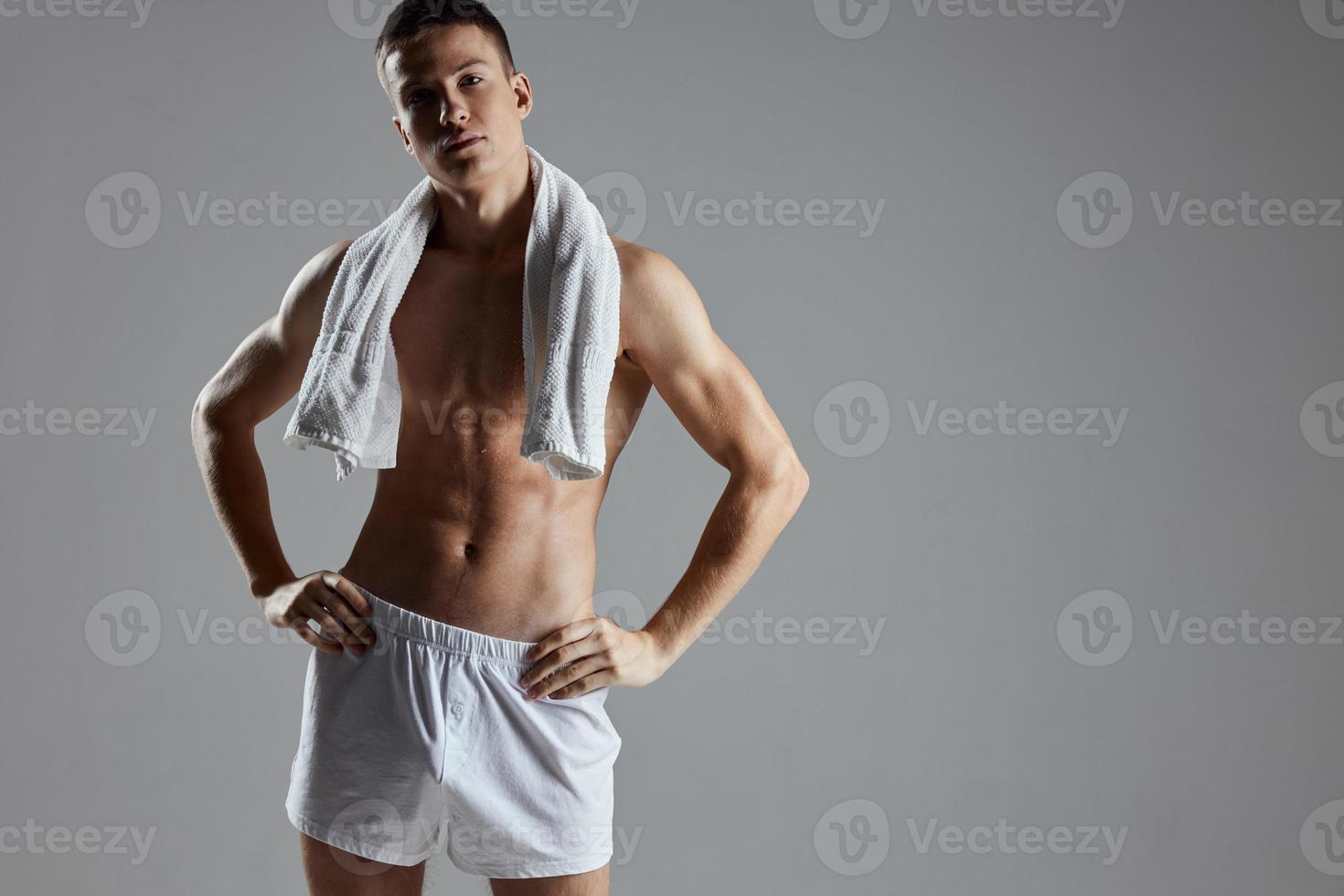 sporty guy in white shorts towel around his neck workout posing photo