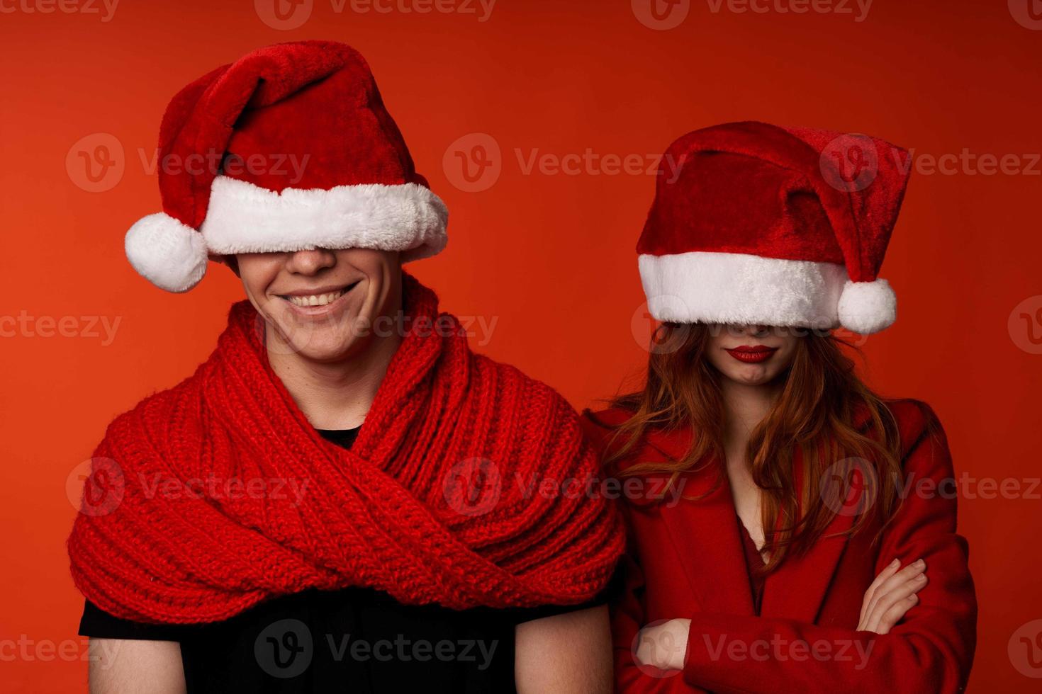 family in santa hats fun new year holiday red background photo