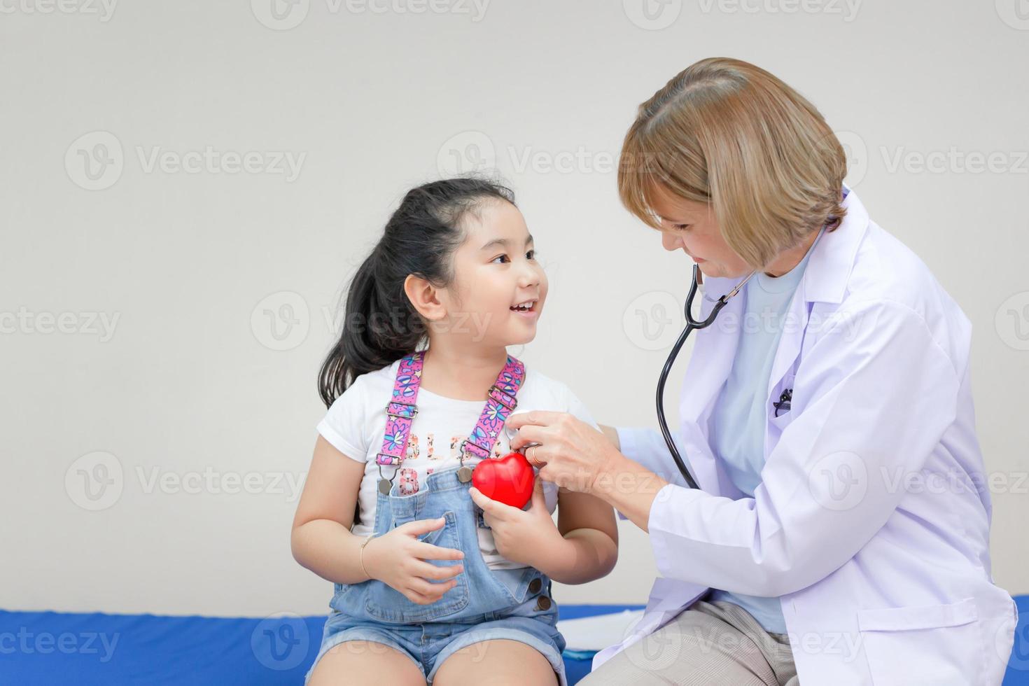 Female doctor examining a little cute girl by stethoscope, Kid on consultation at the pediatrician. Healthcare and medicine concepts photo