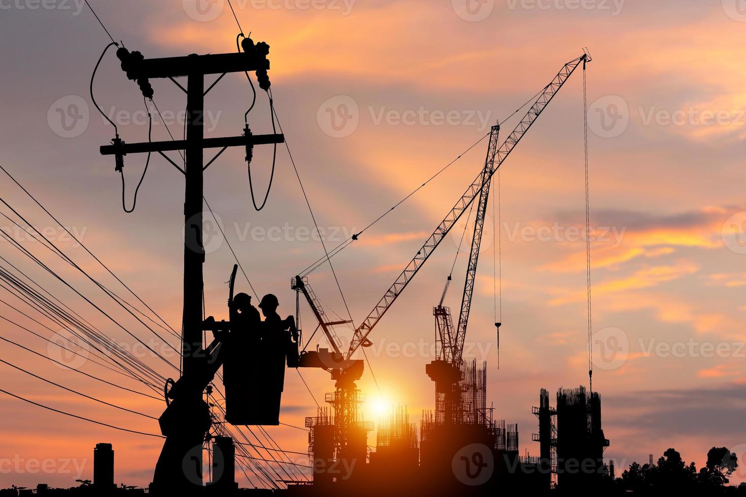 la silueta de un oficial electricista sube a un poste y usa un teleférico para mantener un sistema de línea de alto voltaje, la sombra de un trabajador reparador de liniero electricista en el trabajo de escalada en un poste de energía eléctrica foto