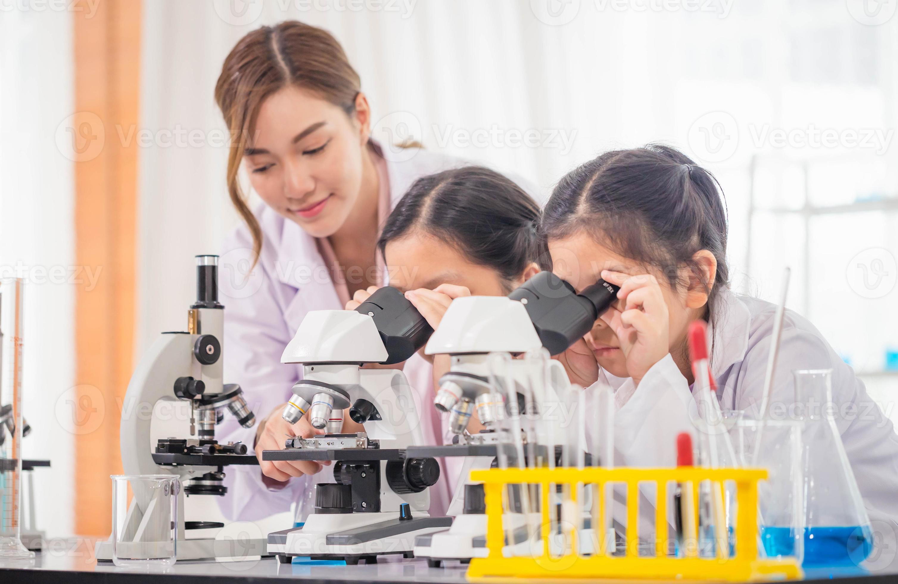 Elementary science class, Child girl looking at slides in through