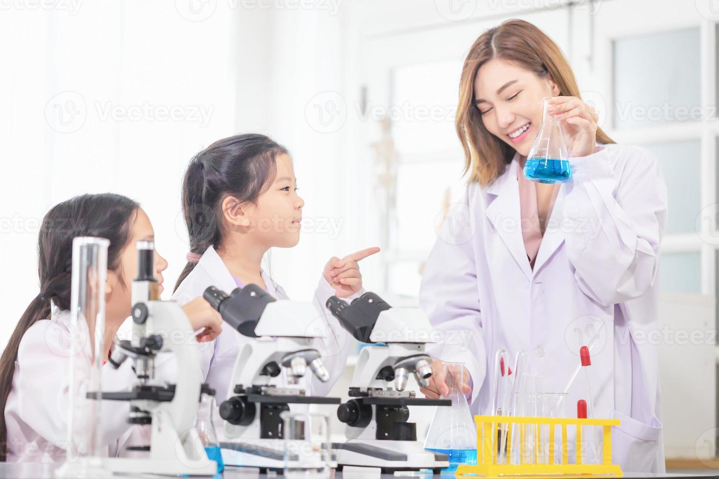 Elementary science class, Cheerful kids girl with teacher scientist in