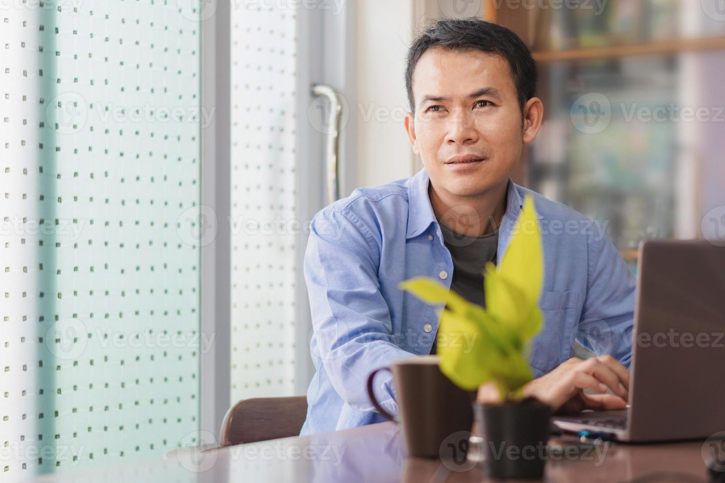 Asian man using laptop at home, Male hands typing on the notebook keyboard, Working from home concepts photo