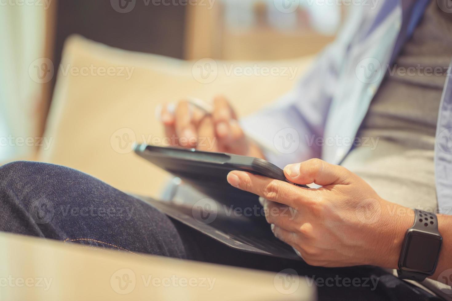Close-up of hands man using a tablet, Asian man using a tablet in coffee shop, Technology in use concepts photo