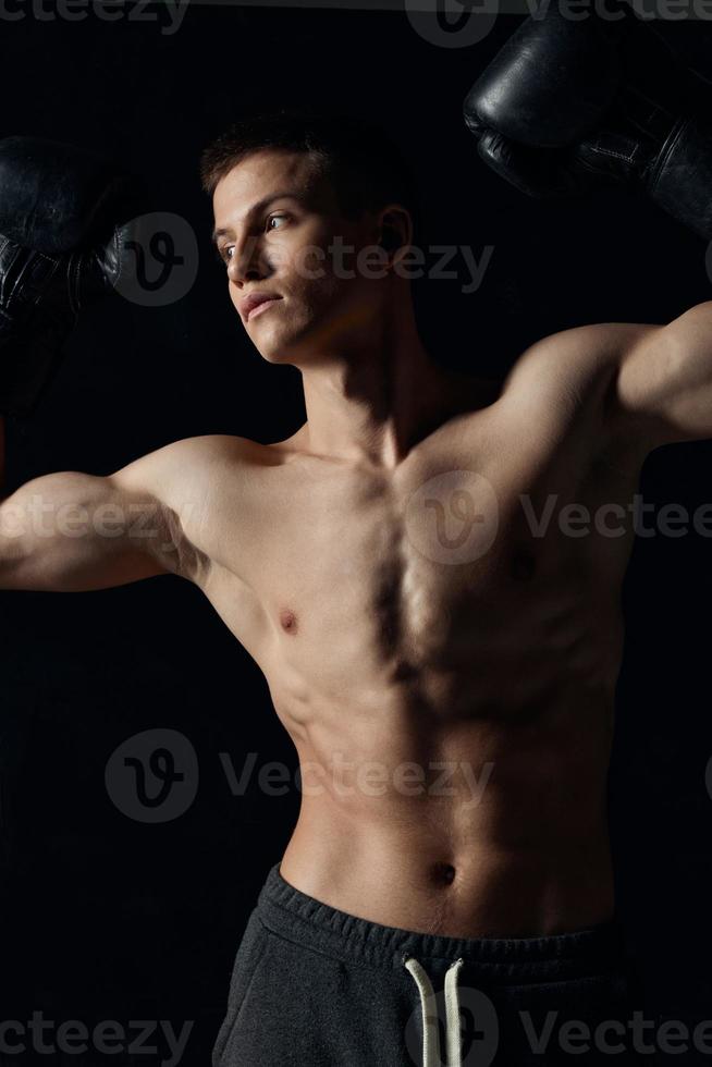 guy with a pumped-up torso gesturing with his hands on a black background boxing gloves fitness athlete photo