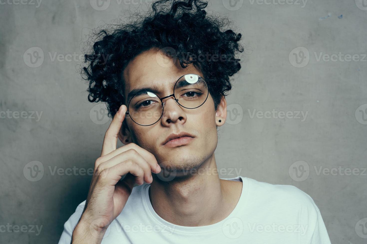 guy with curly hair emotions glasses fashion studio close-up photo