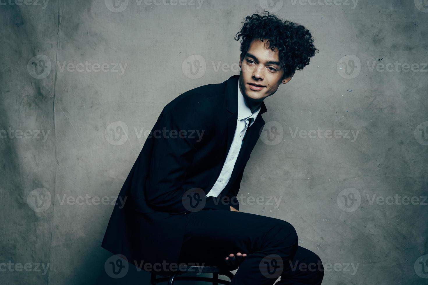 Cheerful curly-haired guy in a suit fashion business official photo
