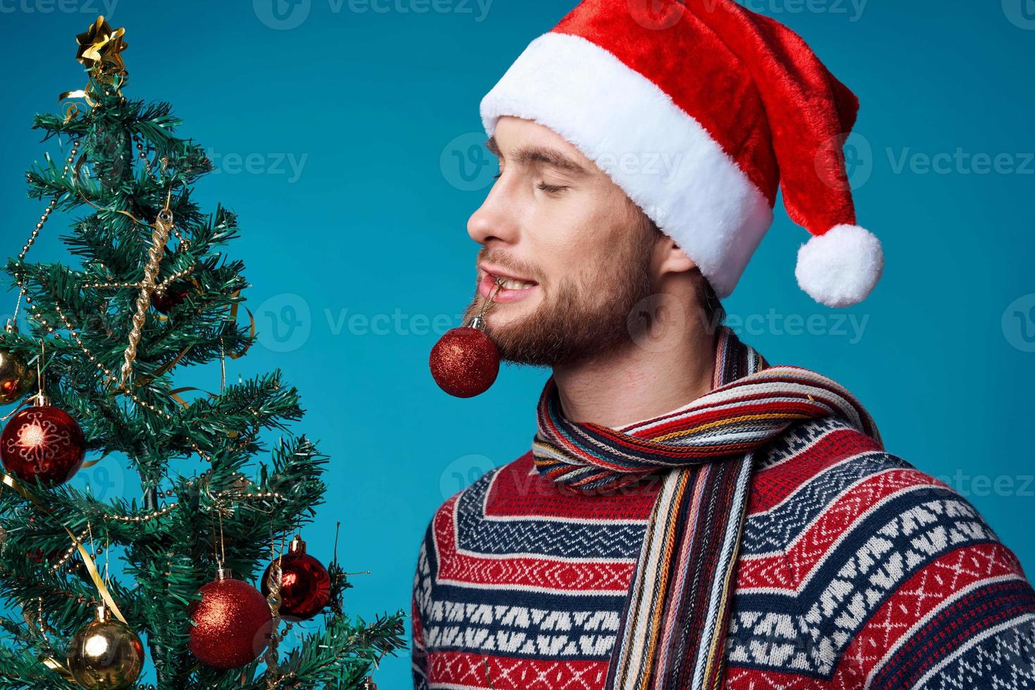 Cheerful man with a tree in his hands ornaments holiday fun red background photo