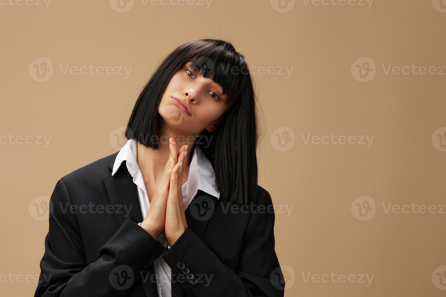 Cute adorable brunet lady in classic suit fold hands in pray look at camera posing isolated on pastel beige studio background. Copy space Banner Offer. Pulp Fiction concept. Fashion Cinema photo