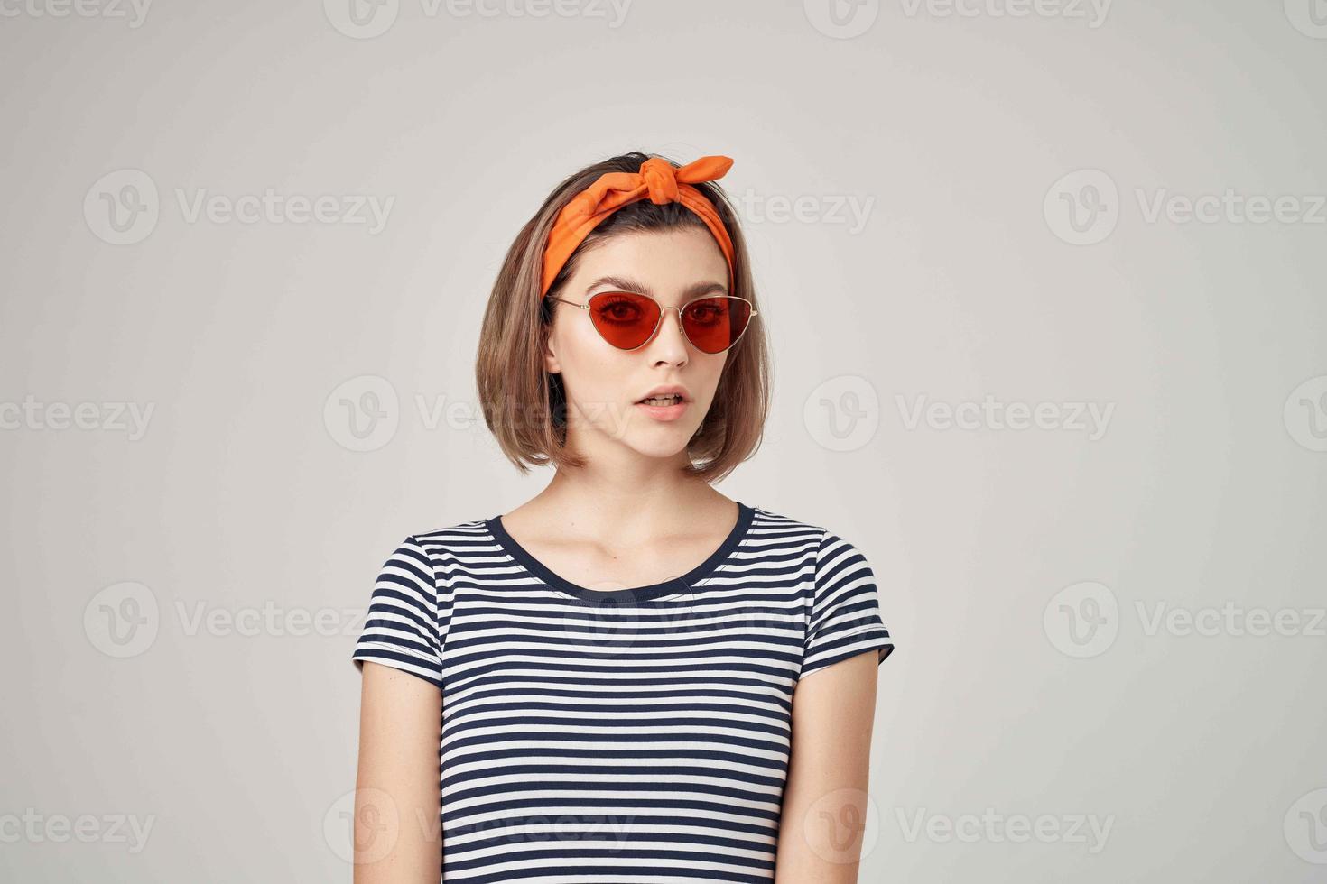 woman in a striped t-shirt with sunglasses with a bandage on her head light background photo