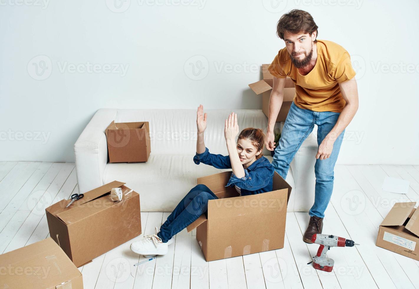 joven Pareja sentado en blanco sofá cajas Moviente estilo de vida foto