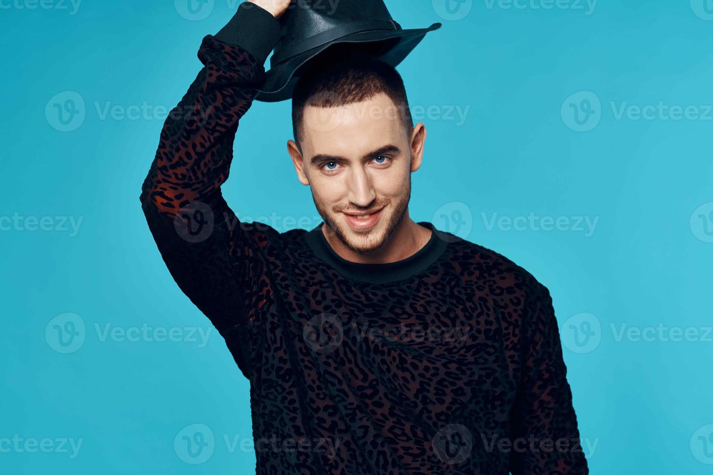 man in black sweater caps posing fashion studio blue background photo