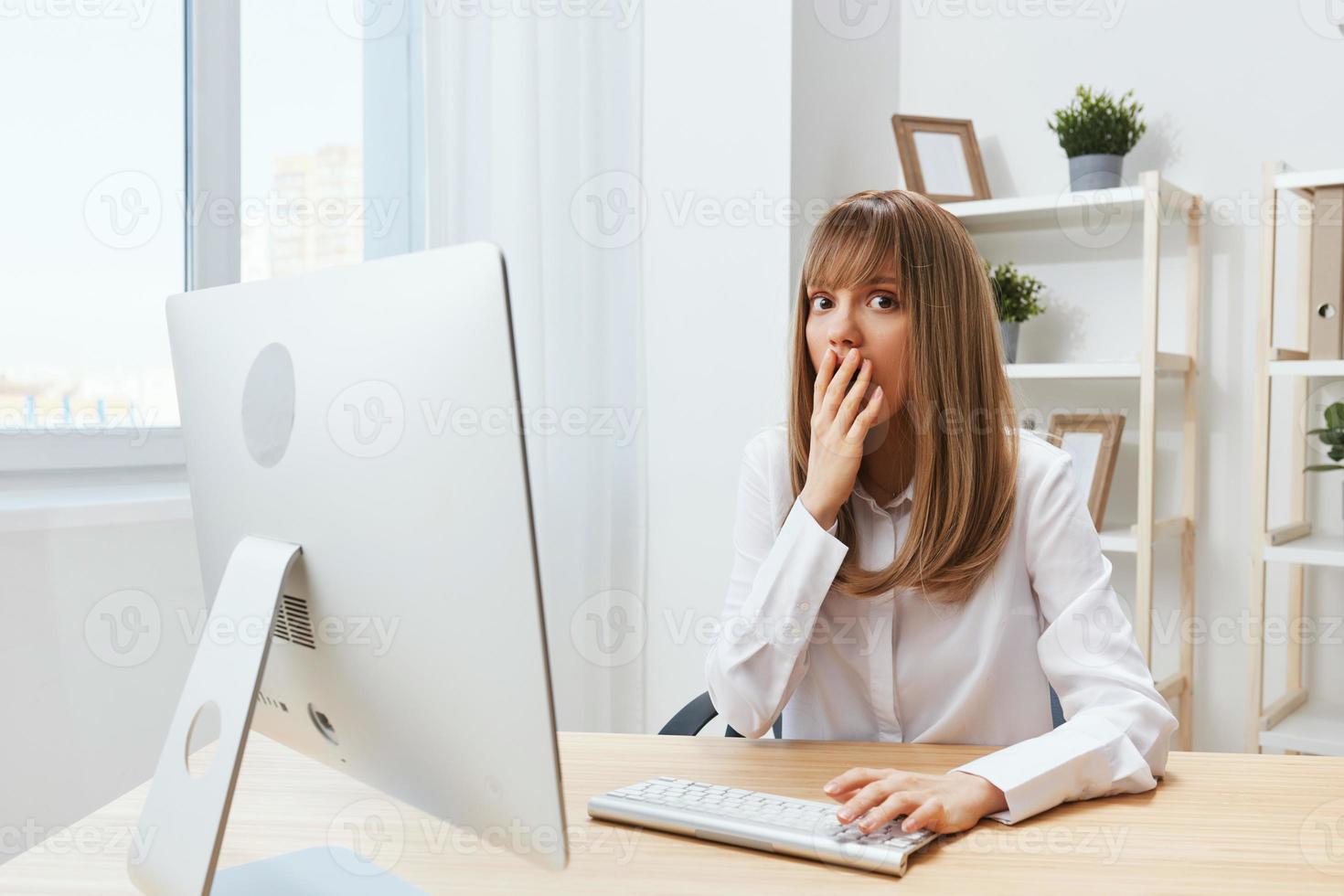 Excited upset adorable blonde businesswoman worker close mouth by hand thinking of problem solution in modern office. Employee work on computer online made a mistake or making decision. Copy space photo
