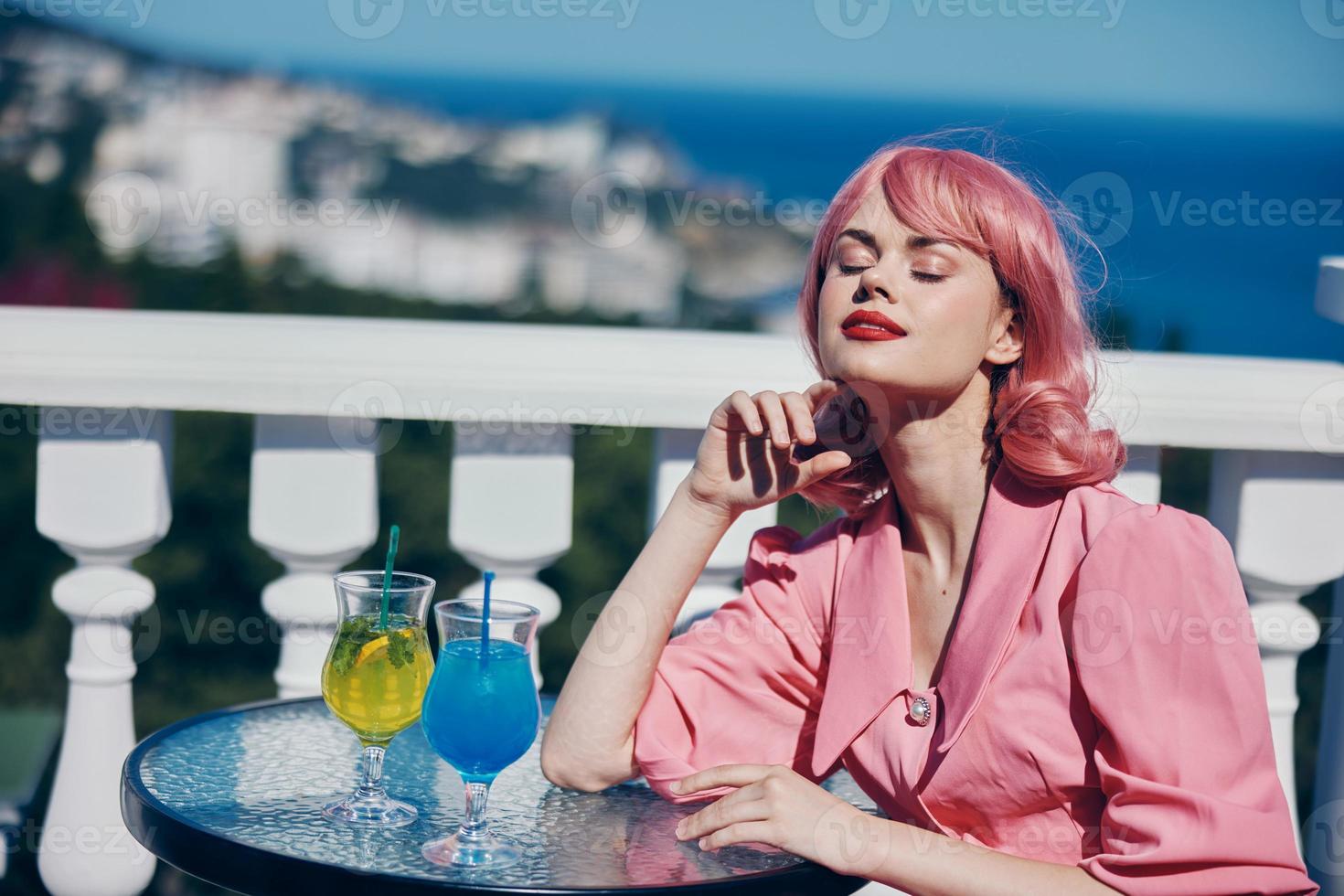 portrait of beautiful woman enjoying a colorful cocktail hotel terrace Happy female relaxing photo