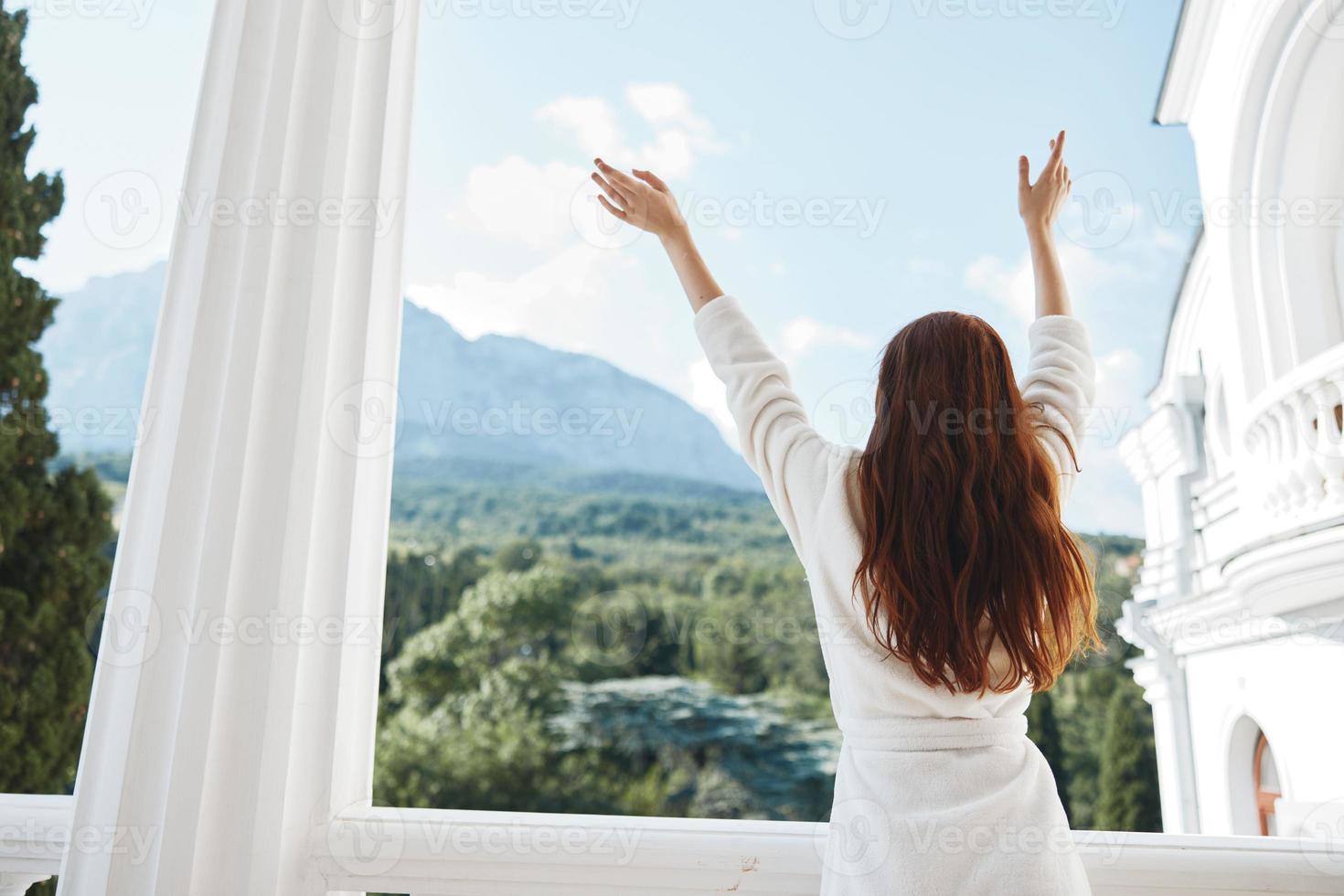 pretty woman looks at a beautiful view from the balcony back view photo