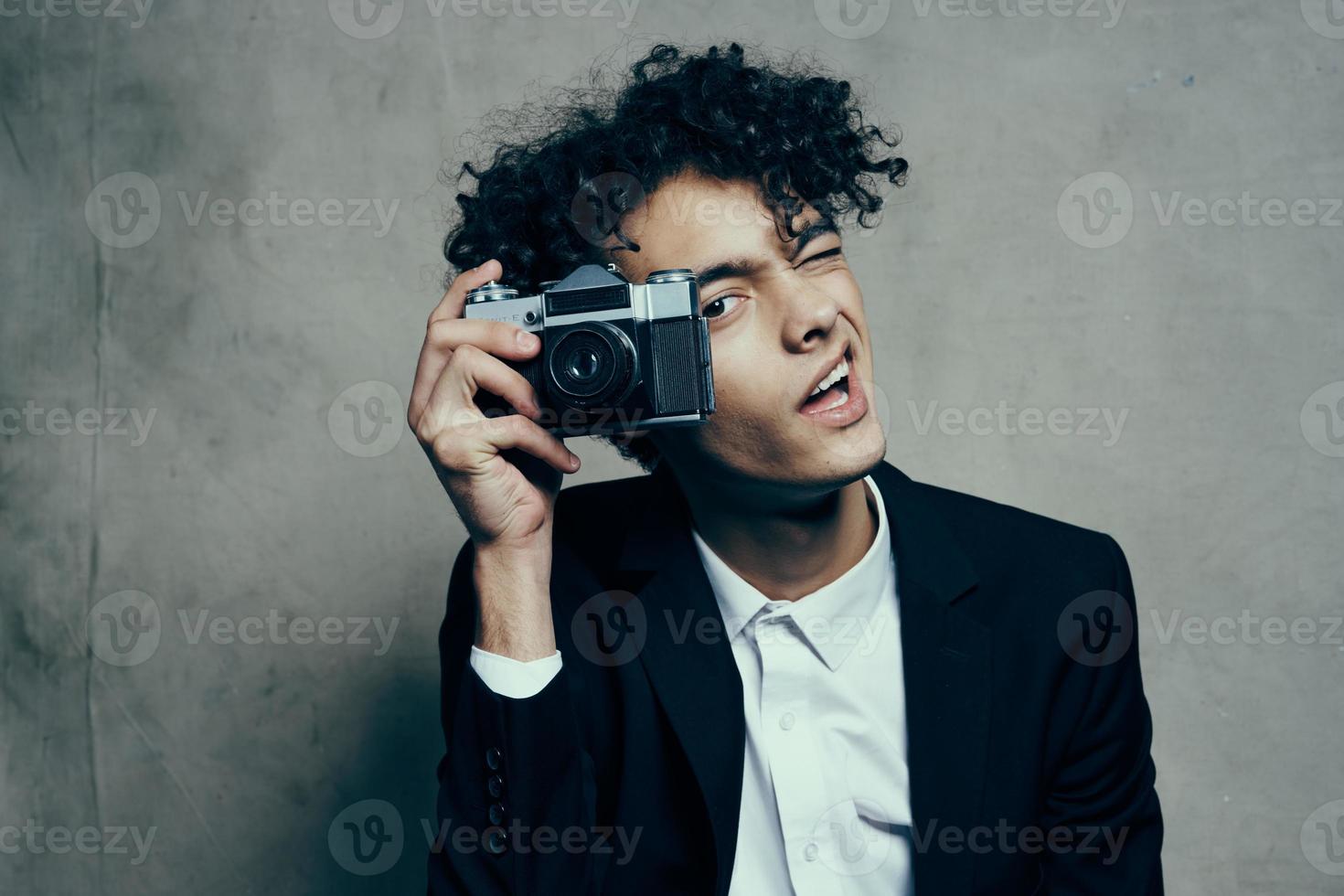 photographer with a camera in a classic suit curly hair Studio Model photo