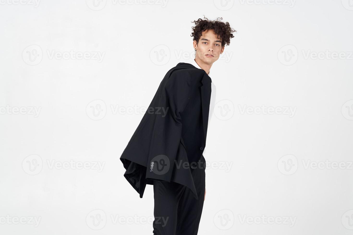 curly guy in a jacket shirt and trousers on a light background cropped view of the model photo