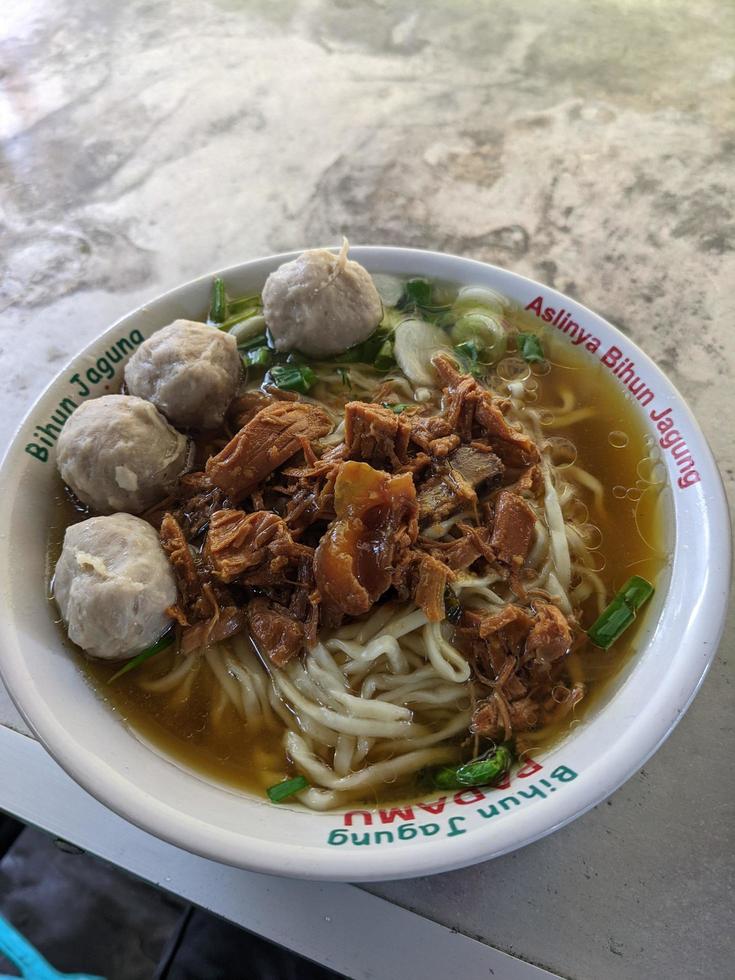 Close up photo of mie ayam traditional food of Javanese with meat ball. The photo is suitable to use for traditional food background, poster and food content media.