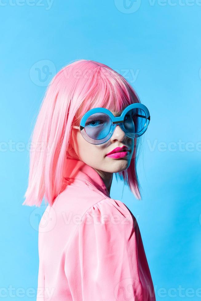 bonito mujer en azul lentes usa un rosado peluca estudio modelo inalterado foto