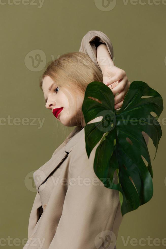 blonde woman red lips palm leaf charm fashion green background photo