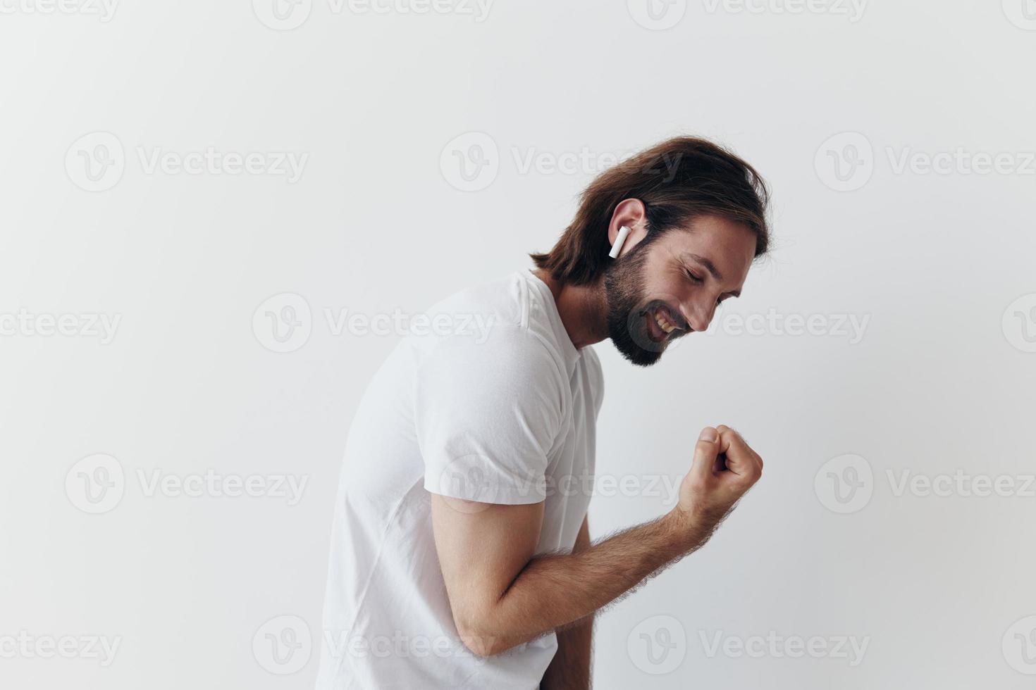 happy man listening to music and smiling in a white t-shirt on a white background happy photo
