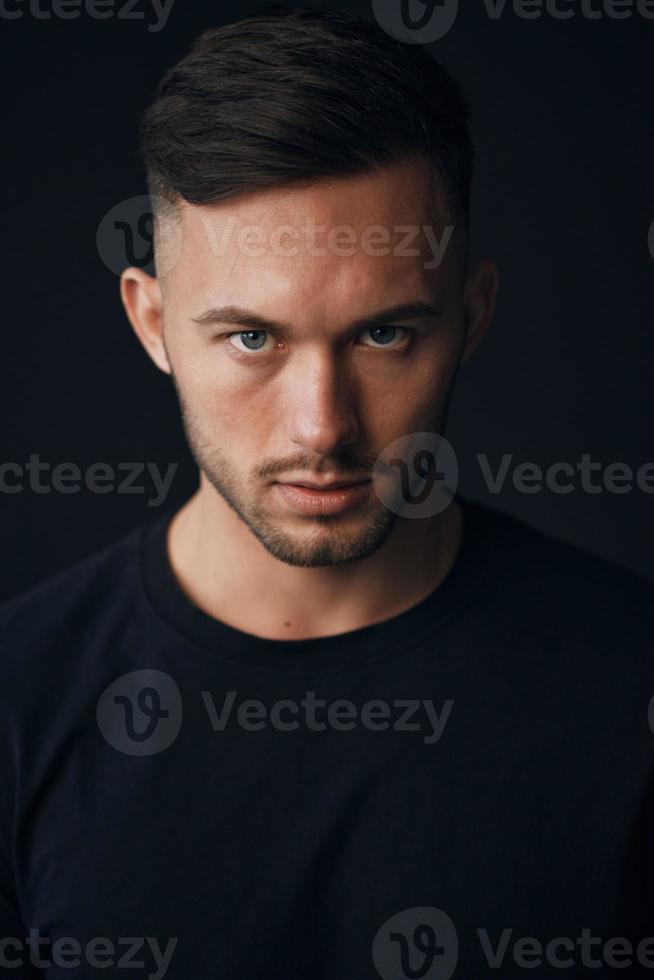 Modelling snapshots. Evil self-confident tanned attractive handsome man in classic suit jacket looks at camera posing isolated in black studio background. Fashion offer. Copy space for ad. Closeup photo